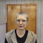 Nicely dressed professional woman with glasses on in front of the camera.